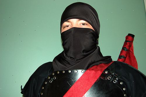 Hoe maak je een ninja outfit. Neem een van de shirts en leg het op een vlakke ondergrond.